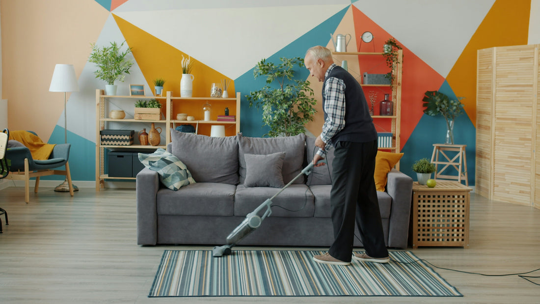 Elderly woman vacuuming a colorful living room floor